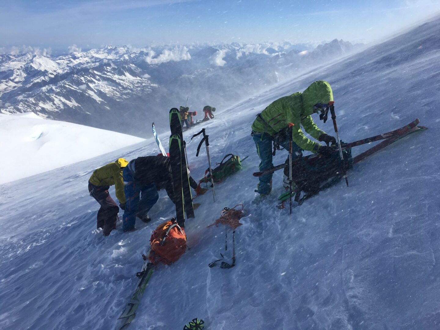 Hikers in full gear hiking up snowy mountain