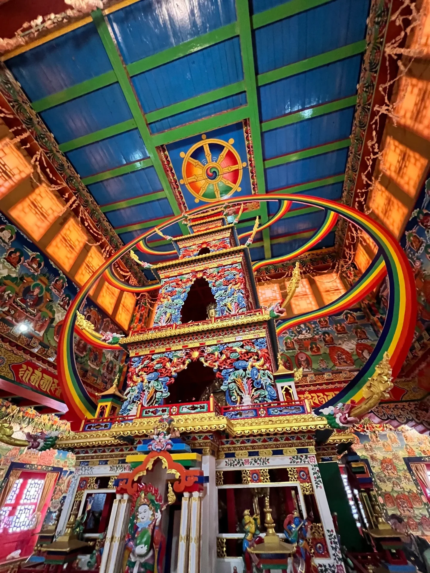 Group of skiers posing on a snowy mountain with lake and peaks behind.
