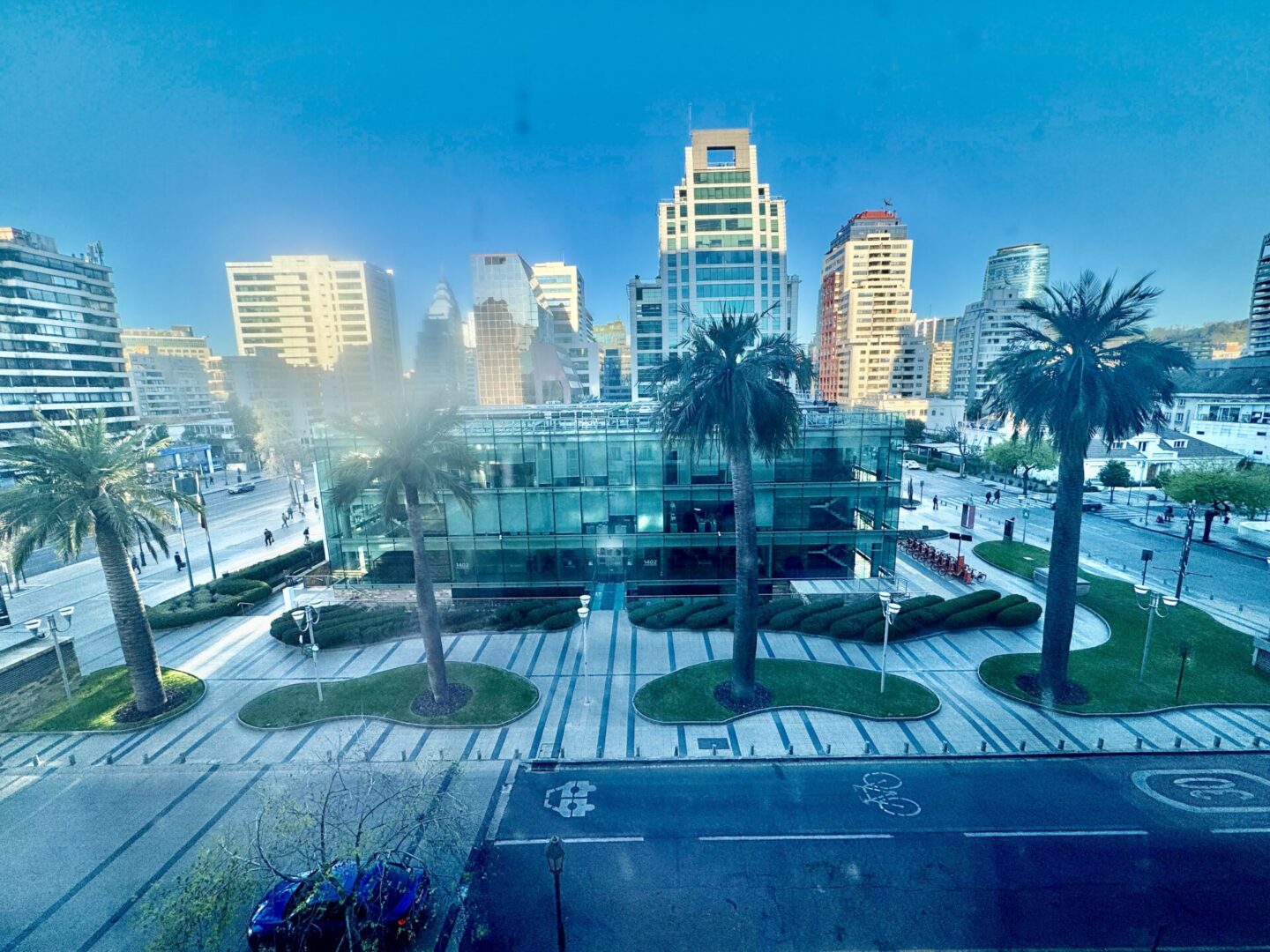 Group of skiers posing on a snowy mountain with lake and peaks behind.