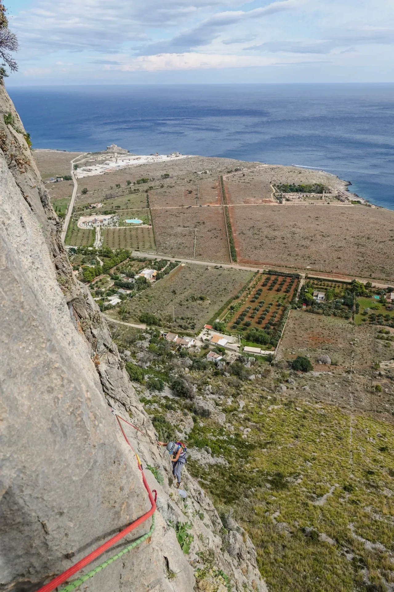 Group of skiers posing on a snowy mountain with lake and peaks behind.